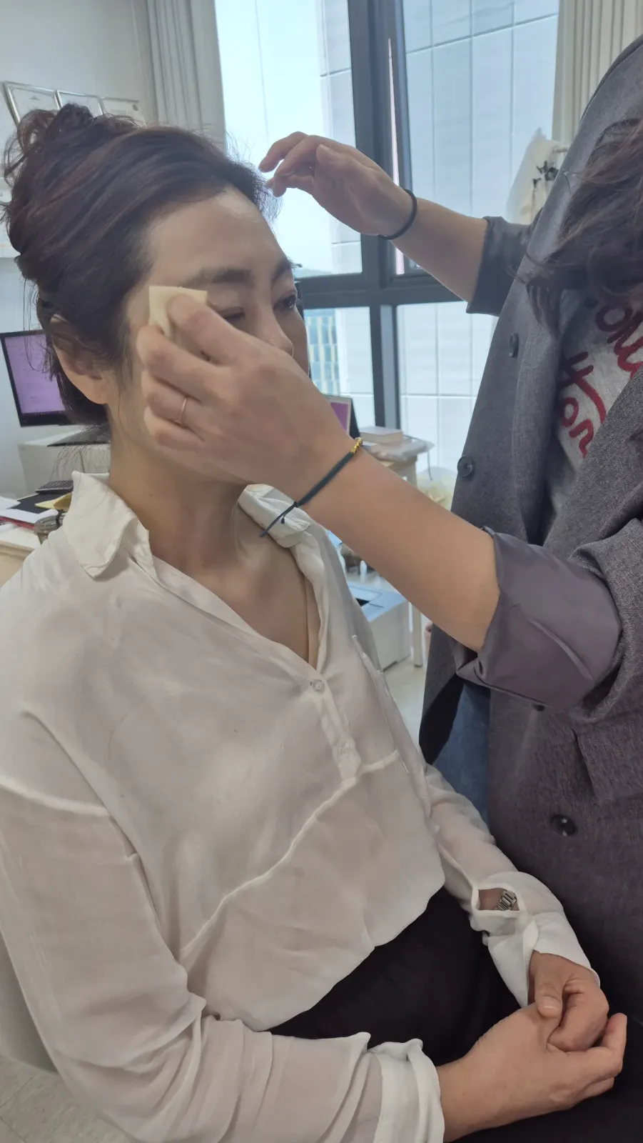 인천 송도 이미지컨설팅 사무실 창가에서 컨설턴트가 고객의 얼굴 톤을 확인하는 모습