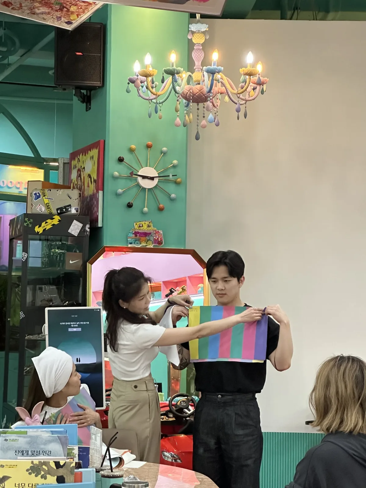 무지개색 컬러 원단을 함께 펼쳐 들고 퍼스널컬러를 진단하는 모습