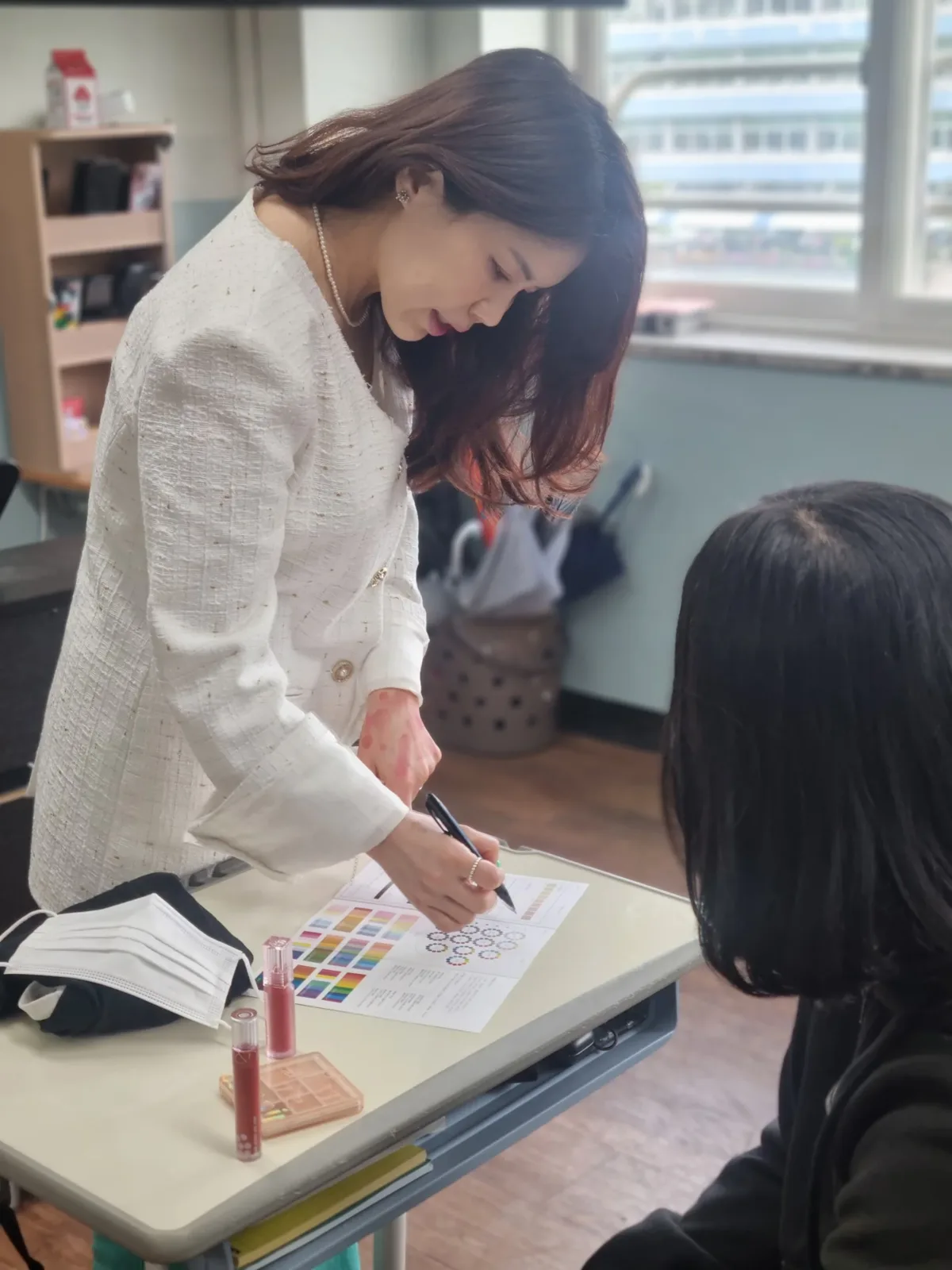 컬러 팔레트 차트에 어울리는 색을 표시하며 진단 결과를 정리하는 모습